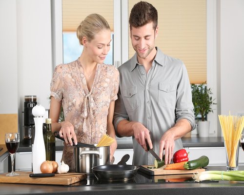 Happy senior Thai couple cooking healthy food in kitchen